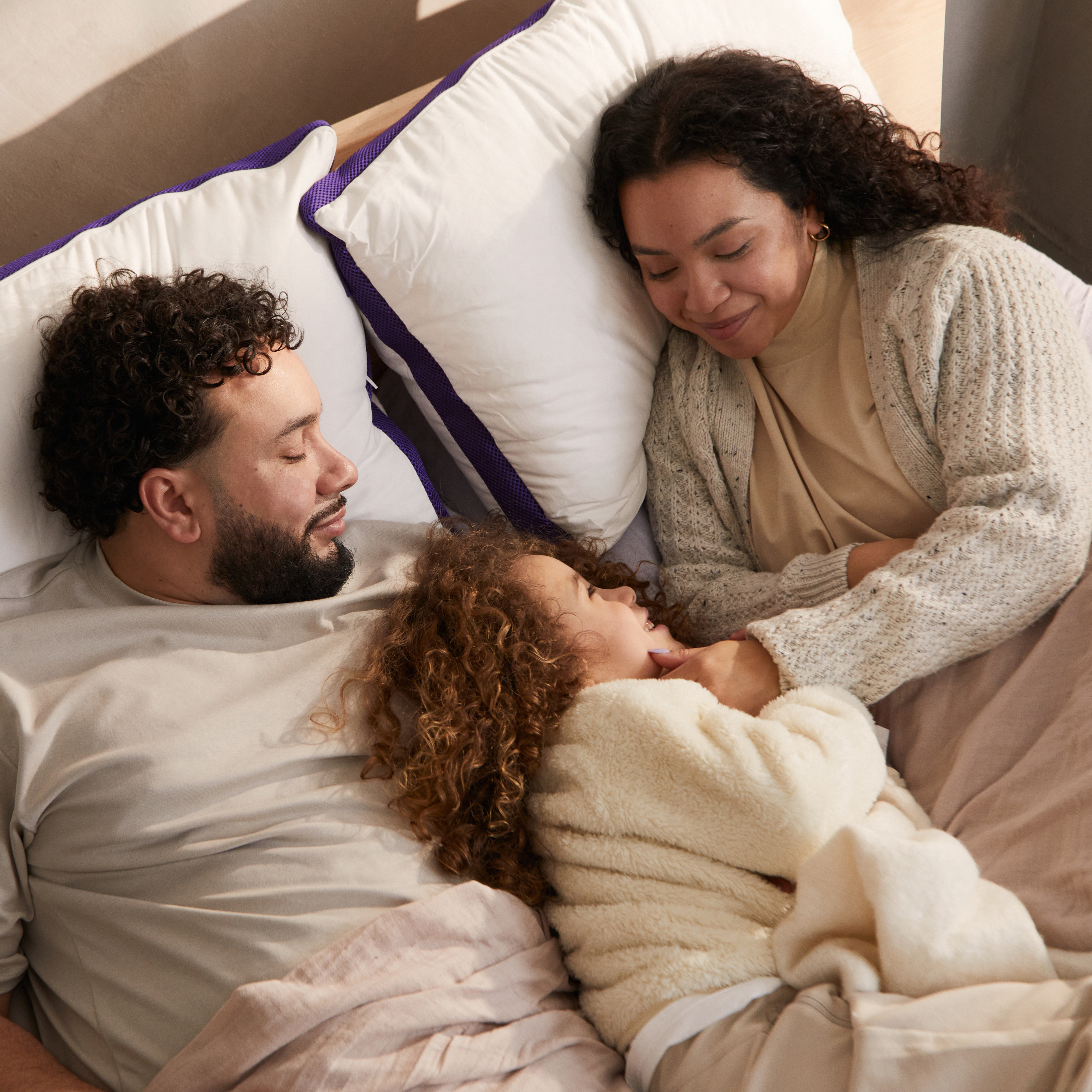 Family resting together in bed